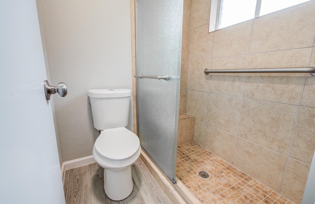 17434 Jolly Boat Dr, Crosby, TX 77532 - bathroom featuring a stall shower, toilet, wood finished floors, and baseboards