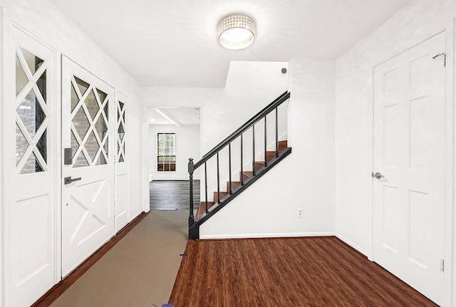 foyer with stairway, baseboards, and wood finished floors