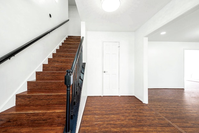 staircase featuring baseboards, wood finished floors, and recessed lighting