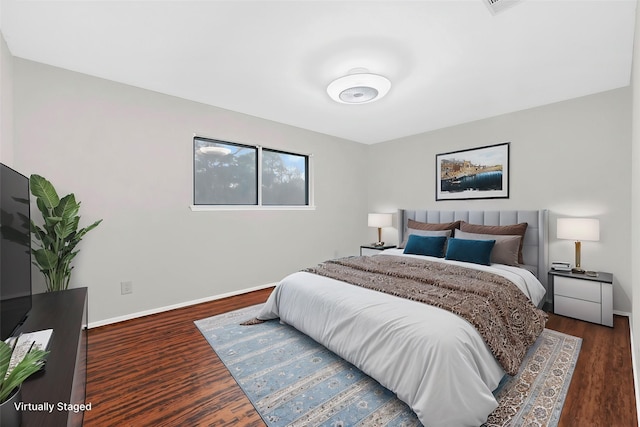 bedroom with wood finished floors and baseboards