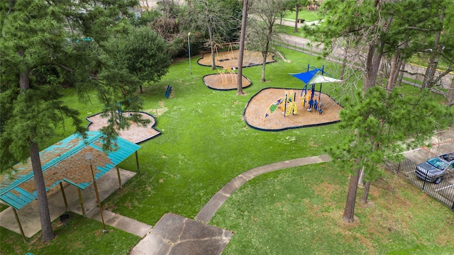 exterior space featuring a lawn, fence, and playground community