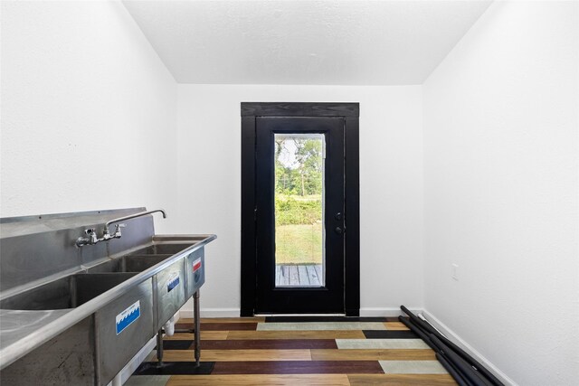 doorway to outside featuring wood finished floors and baseboards