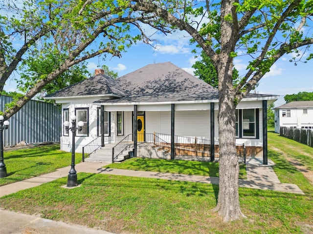 view of front facade with fence, a porch, and a front yard
