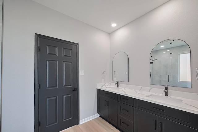 2006 Deer Vly, Missouri City, TX 77459 - bathroom featuring double vanity, tiled shower, a sink, and wood finished floors