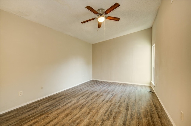 unfurnished room with baseboards, ceiling fan, a textured ceiling, and dark wood-style flooring