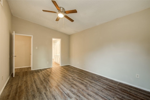 spare room with dark wood-style floors, ceiling fan, vaulted ceiling, and baseboards