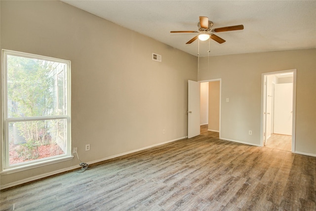 unfurnished room featuring visible vents, ceiling fan, wood finished floors, and baseboards