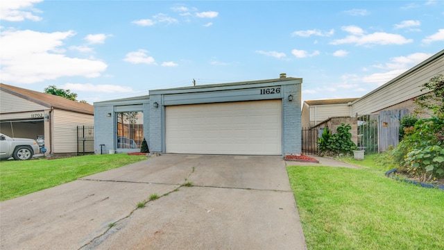 view of front of home featuring a front lawn, driveway, a garage, and fence