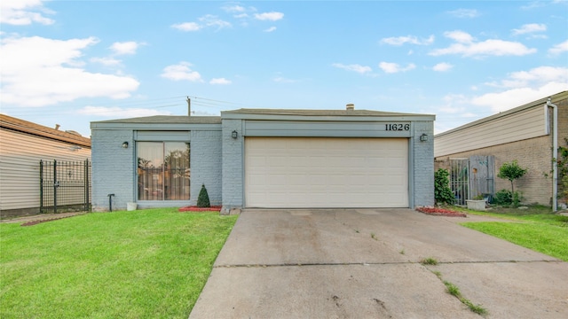 view of front of home featuring brick siding, fence, a garage, driveway, and a front lawn
