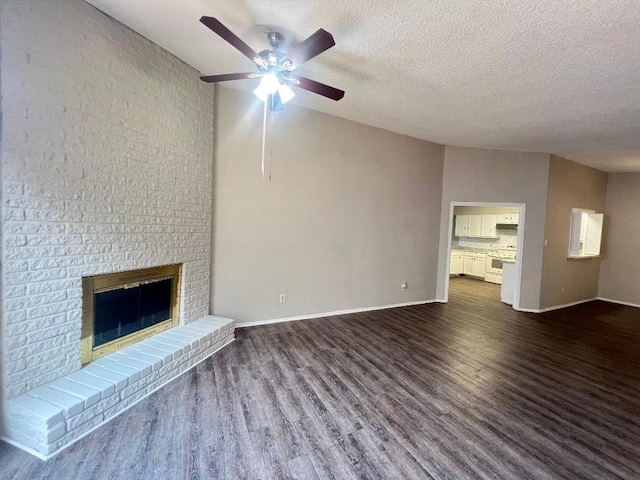 unfurnished living room with a brick fireplace, dark wood-style floors, a textured ceiling, and ceiling fan
