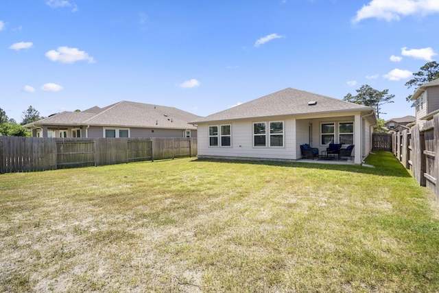 back of property with a fenced backyard, a patio area, and a lawn