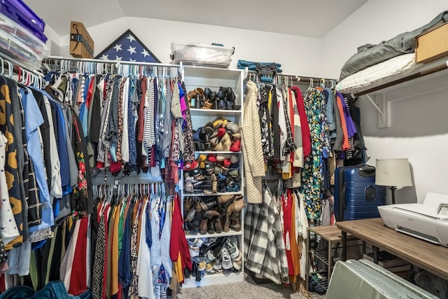 spacious closet featuring vaulted ceiling and carpet floors