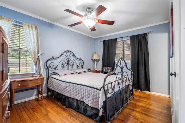 bedroom with a ceiling fan, baseboards, crown molding, and hardwood / wood-style floors