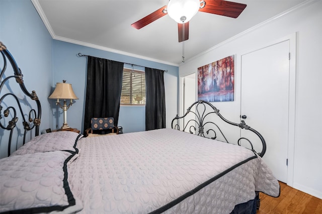 bedroom with ceiling fan, crown molding, and wood finished floors
