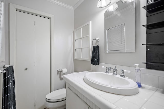 bathroom with backsplash, toilet, ornamental molding, and vanity