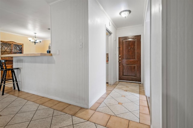 corridor with a chandelier, light tile patterned floors, and crown molding