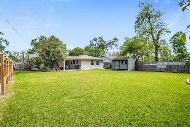 view of yard with a patio area, an outbuilding, a shed, and a fenced backyard