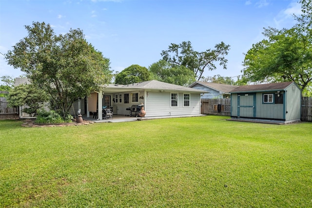 back of house featuring a patio area, a storage shed, a lawn, a fenced backyard, and an outdoor structure