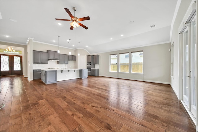 29167 Turning Springs Ln, Fulshear, TX 77441 - unfurnished living room with dark wood finished floors, crown molding, visible vents, and ceiling fan with notable chandelier