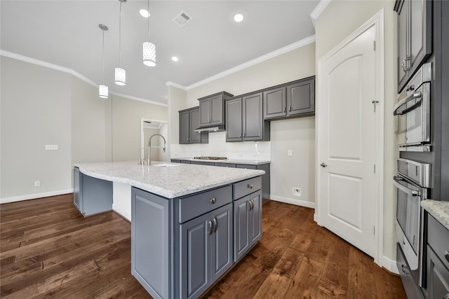 29167 Turning Springs Ln, Fulshear, TX 77441 - kitchen featuring a sink, decorative backsplash, a center island with sink, ornamental molding, and visible vents