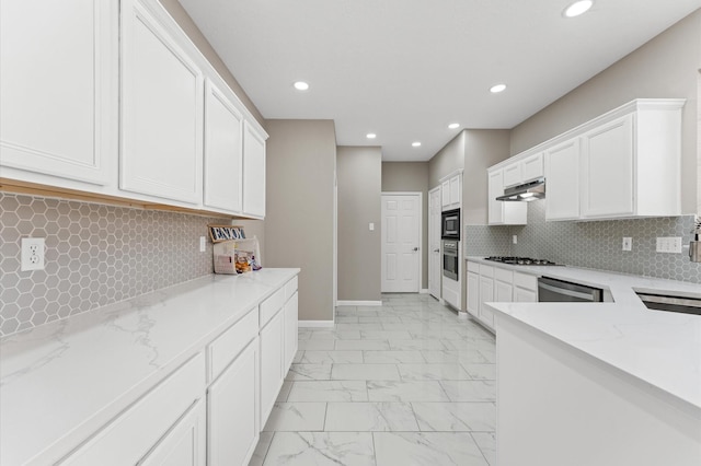 15306 Goodman St, Houston, TX 77084 - kitchen with stainless steel appliances, light marble finish flooring, under cabinet range hood, recessed lighting, and white cabinets