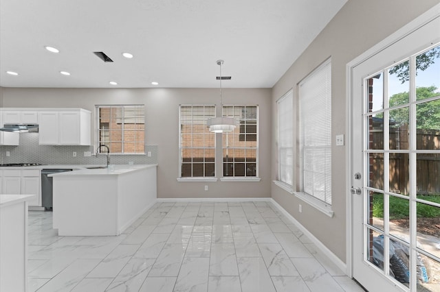 15306 Goodman St, Houston, TX 77084 - kitchen with appliances with stainless steel finishes, a sink, light marble finish flooring, under cabinet range hood, and baseboards