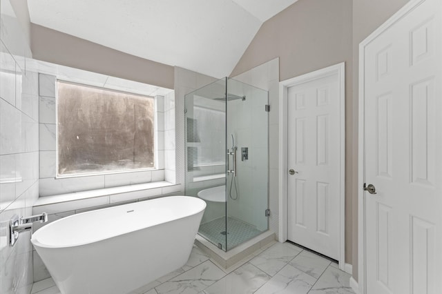 15306 Goodman St, Houston, TX 77084 - bathroom featuring a shower stall, a soaking tub, marble look tiles, and vaulted ceiling