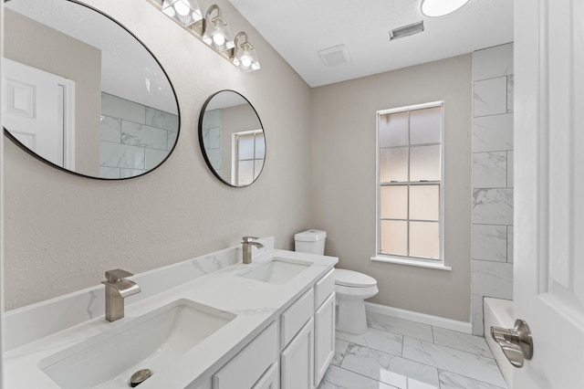 15306 Goodman St, Houston, TX 77084 - bathroom with marble look tiles, toilet, baseboards, and double vanity