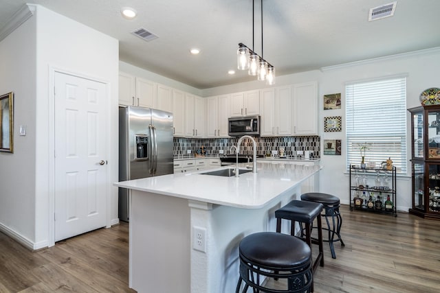 7702 Royal Oasis Ln, Cypress, TX 77433 - kitchen featuring wood finished floors, visible vents, stainless steel appliances, and a sink