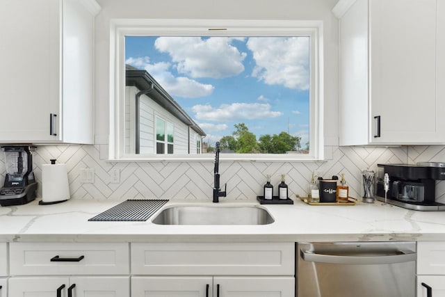 kitchen with dishwasher, white cabinets, decorative backsplash, and a sink