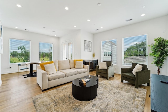 living room featuring recessed lighting, visible vents, and light wood-type flooring