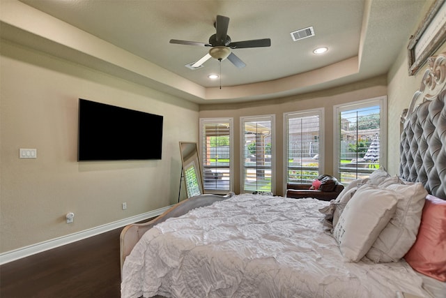 12603 Mostyn Ct, Magnolia, TX 77354 - bedroom with a ceiling fan, baseboards, visible vents, wood finished floors, and a raised ceiling