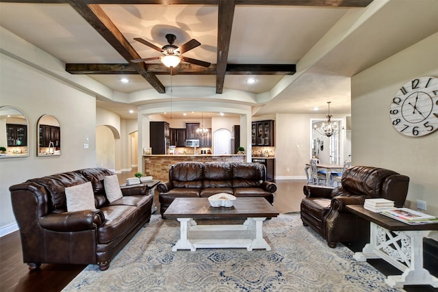 12603 Mostyn Ct, Magnolia, TX 77354 - living area with dark wood-type flooring, baseboards, ceiling fan with notable chandelier, and arched walkways