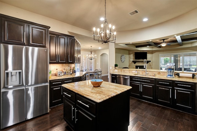12603 Mostyn Ct, Magnolia, TX 77354 - kitchen with stainless steel appliances, ceiling fan with notable chandelier, visible vents, open floor plan, and arched walkways