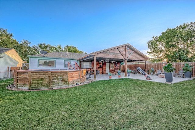 back of property featuring a patio area, a lawn, and a fenced backyard