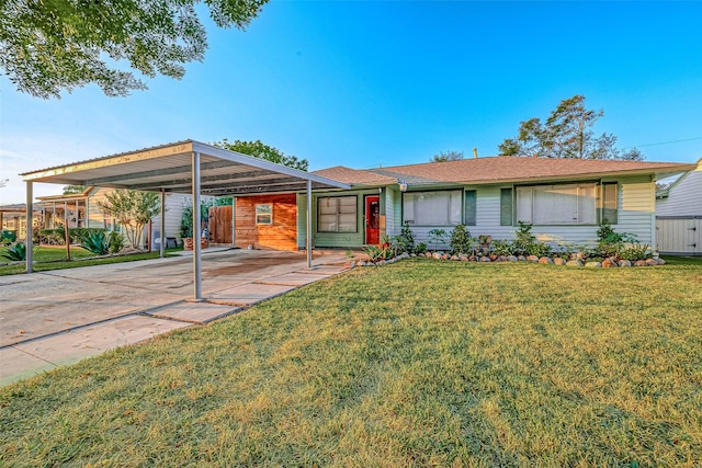 ranch-style home with driveway, a front lawn, and an attached carport