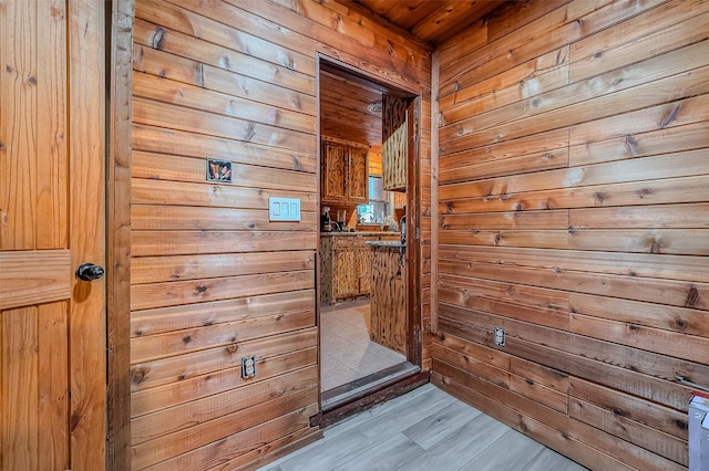 doorway to outside featuring wood walls and wood ceiling