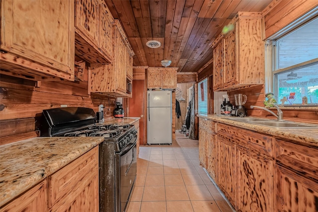 kitchen with a sink, wooden ceiling, gas stove, visible vents, and freestanding refrigerator