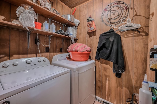 laundry area featuring wooden walls, washer and dryer, and laundry area
