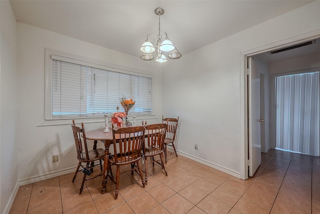 dining space with visible vents, a healthy amount of sunlight, light tile patterned flooring, baseboards, and a chandelier