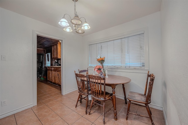dining area featuring a chandelier, baseboards, and light tile patterned floors