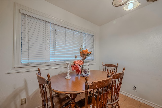 dining room with light tile patterned floors, baseboards, and a wealth of natural light