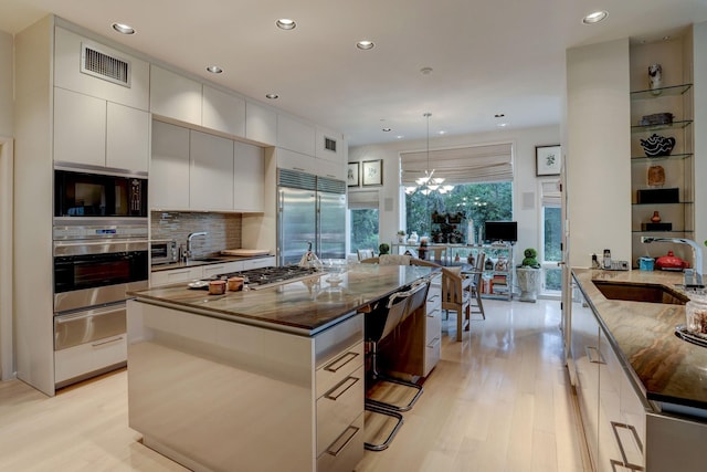 2003 Arrowwood Cir N, Houston, TX 77063 - kitchen featuring a sink, built in appliances, visible vents, a warming drawer, and modern cabinets