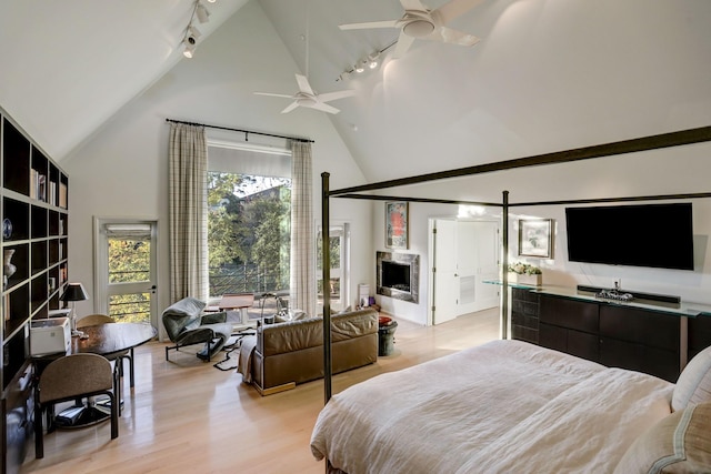 2003 Arrowwood Cir N, Houston, TX 77063 - bedroom with track lighting, light wood-style flooring, a fireplace, and high vaulted ceiling