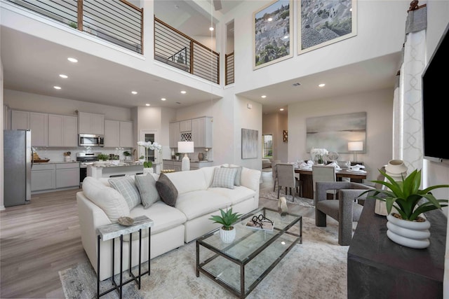 16833 Needlepoint Dr, Conroe, TX 77302 - living room featuring light wood-style flooring, a towering ceiling, and recessed lighting
