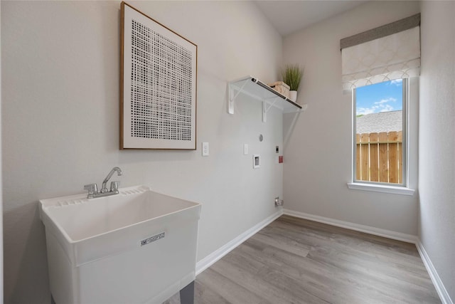 16833 Needlepoint Dr, Conroe, TX 77302 - clothes washing area with laundry area, hookup for an electric dryer, a sink, light wood-type flooring, and hookup for a washing machine
