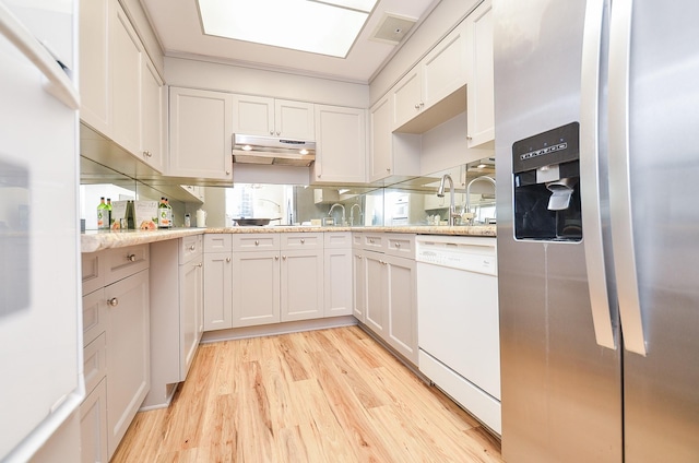 kitchen with light wood-style flooring, stainless steel fridge, fridge, visible vents, and white dishwasher