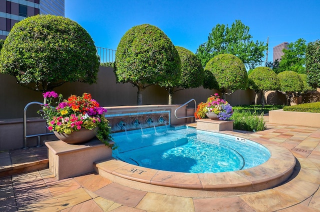 view of swimming pool featuring an in ground hot tub and fence