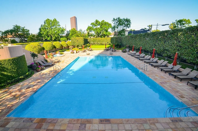 community pool featuring a patio area and a fenced backyard