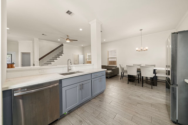 kitchen featuring a sink, ceiling fan with notable chandelier, light wood finished floors, appliances with stainless steel finishes, and visible vents
